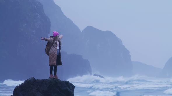 Slow Motion Excited Inspired Woman on Sea Rock and Rising Hands Up in the Air