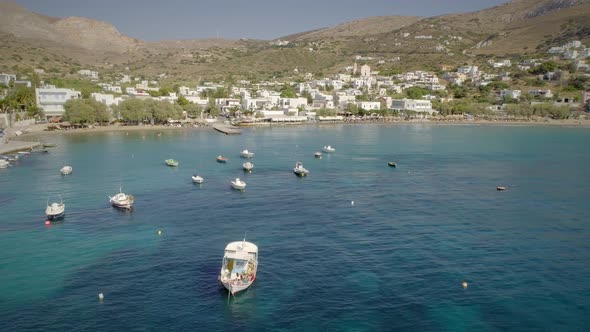 Aerial view of fishing boats anchored on the seashore in Greece.
