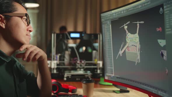 Asian Engineer Thinking While Work On Personal Computer And 3D Printer, Screen Shows 3d Drone