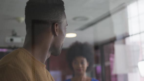 Happy african american male and female business colleagues brainstorming in meeting room