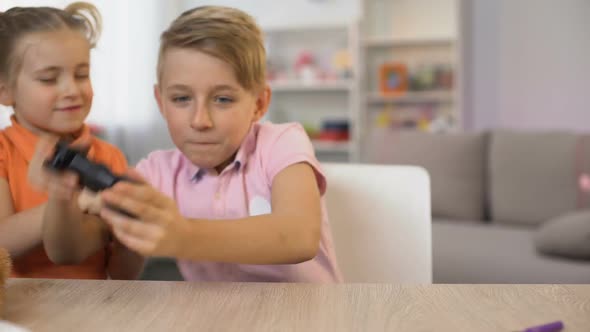 Little Girl Disturbing Brother Playing Console Game, Children Fighting Joystick