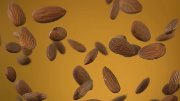 Close Up of Almonds Bouncing and Rotating on the Yellow Background