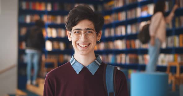 Portrait of Caucasian Male Student Smiling at Camera in School Library