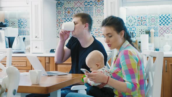 Family with Baby Boy Use Digital Devices at Breakfast Table