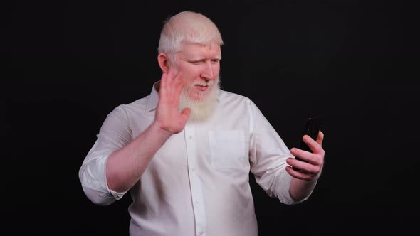 Funny Man with Albinism Using Phone and Talking Online on Black Background.