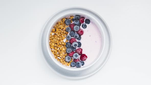 Smoothie bowls with granola, blueberries and raspberries on a white background. Healthy breakfast st