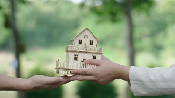 Man Is Handing A Model House To Other Hands