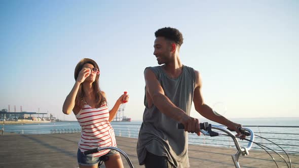 Portrait of a Mixed Race Couple Having Fun on Tandem Bicycle Outdoors Near the Sea Slow Motion