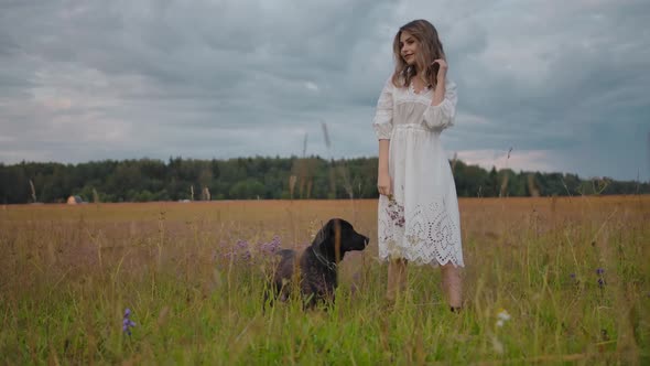 Romantic Gentle Woman with Dog in Rural Field