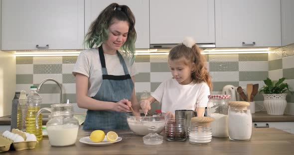 Two Girls Preparing Cookies Together in Kitchen, Kids Stir Flour