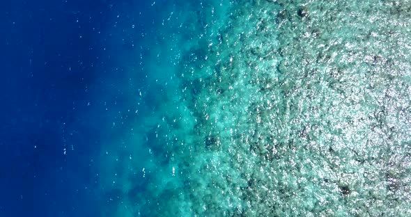 Natural overhead tourism shot of a summer white paradise sand beach and blue ocean background in 4K