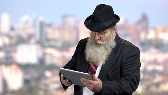 Surprised Senior Businessman Holding Computer Tablet