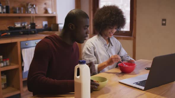 Couple watching computer while having breakfast