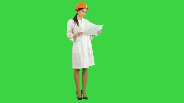 Young Female Architect Holding Blueprints and Inspecting Construction on a Green Screen, Chroma Key