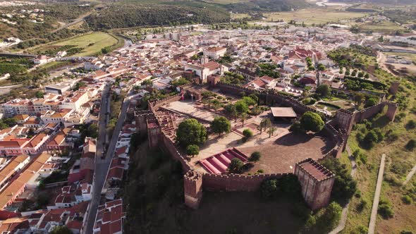 Fortified red sandstone walled city and Castle of Silves, Algarve, Portugal. Orbiting shot