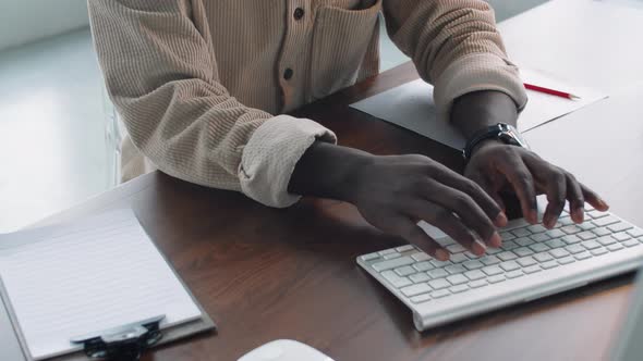 Young Afro-American Businessman Working on Computer and Taking Notes