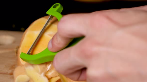 Locked Off View Of Peeling Skin Off Butternut Pumpkin With Vegetable Peeler. Close Up