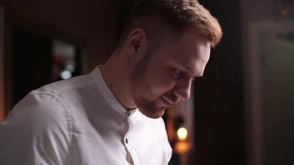 Close-up of Bearded Handsome Man Using Laptop on Dark Room. Young Freelancer Using Laptop