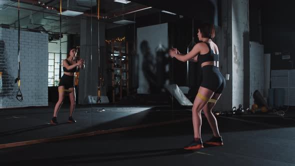 A Woman in the Gym Doing Exercise for Her Butt and Legs Including Squatting
