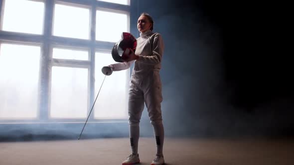 A Young Woman Fencer Putting on a Protective Helmet and Gets Into Position - Smoky Studio