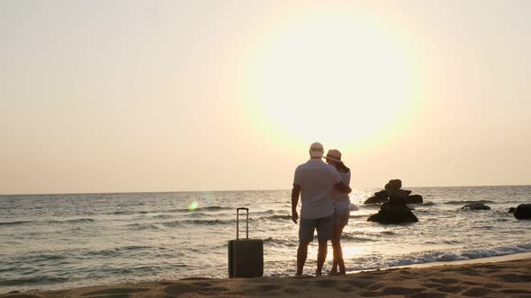 Romantic Couple of Lovers, Silhouettes. Travelers Hug and Enjoy Sea View, Sunrise or Sunset, on the