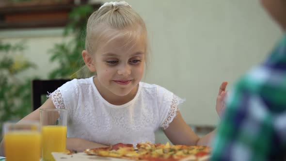 Smiling Girl Looking at Pizza and Choosing Best Slice, Family Food Traditions