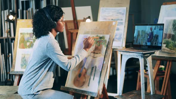 African Ethnicity Lady is Painting While Having a Video Lesson