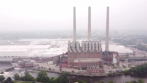 Dam And Otto C. Eckert Municipal Power Plant With Three Smokestack On A Misty Day In Lansing, Michig