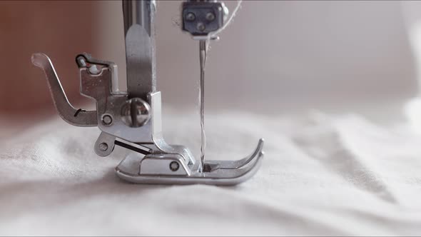 The Silver Presser Foot of the Sewing Machine Presses the Fabric and Stitches It with a Needle. The alt