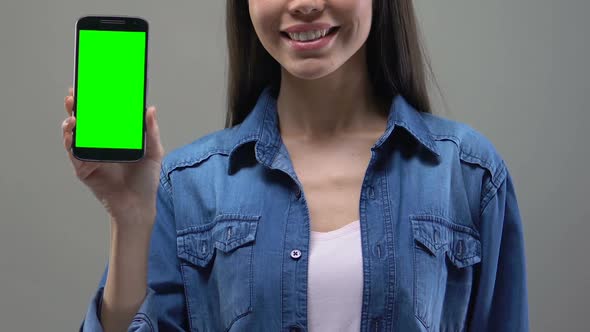 Young Asian Lady Showing Smartphone With Green Screen, Application Development