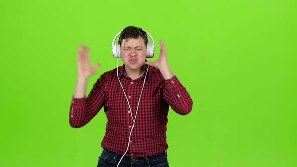 Guy Listens To Energetic Music in Headphones and Dances. Green Screen. Slow Motion