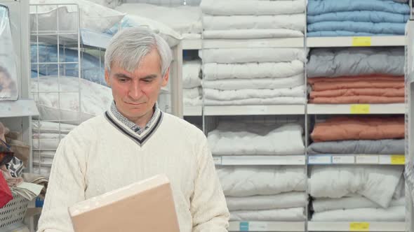 Senior Man Shopping for Bedroom Textile at Furnishings Store