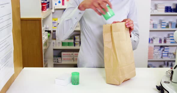 Pharmacists packing medicine in paper bag