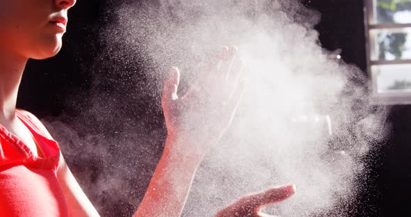 Woman dusting his hands with chalk powder