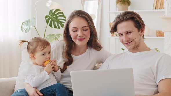 Portrait of Caucasian Family Uses Laptop Sitting on Couch at Home