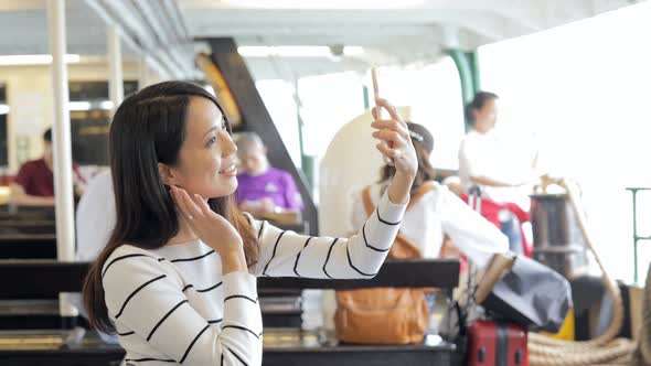 Woman taking photo with cellphone on star ferry in Hong Kong