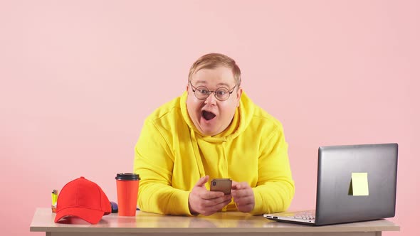 Shocked Surprised Plump Man Staring at Camera with Open Mouth While Working on Smartphone