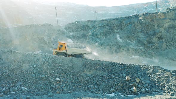 Loaded Truck is Riding Along the Slopes of the Mine Site