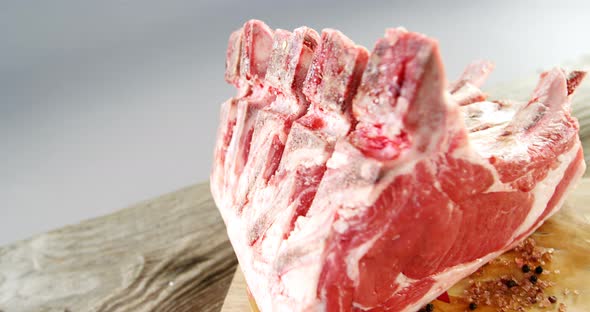 Raw beef ribs and ingredients on wooden board