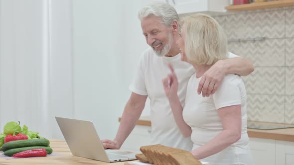 Loving Old Couple Doing Video Call on Laptop in Kitchen