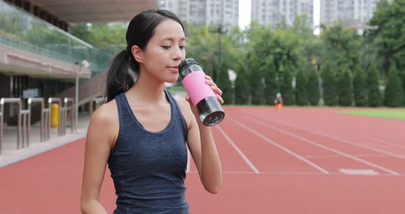 Sport woman drink of water in sport arena 