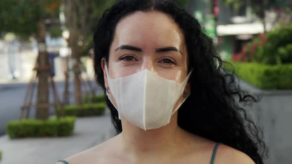 Closeup of an Adult Woman Wearing a Medical Mask Looking Around and Looking at the Camera on an