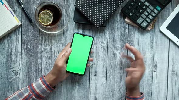 Top View of Man Hand Using Smart Phone on Office Desk Showing Frustration