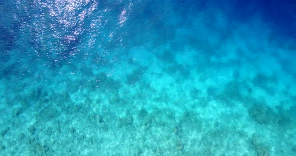 Natural flying abstract shot of a sunshine white sandy paradise beach and blue water background in 4