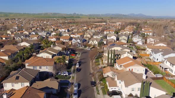 Aerial view flying above new housing development neighbourhood rooftops in Central valley of Califor