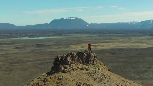 Photographer Man Traveler on Mountain Top. Iceland. Aerial View