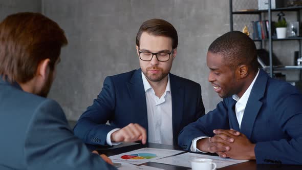 Young people in suits discussing problems in business in a loft