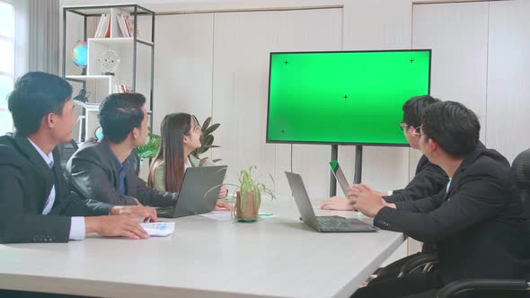 Asian Team Have Meeting In A Conference Room with Tv Mock Up Green Screen And Waving Hands