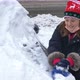 young girl helps clear snow from a car in winter after a snowstorm in a parking lot. - VideoHive Item for Sale