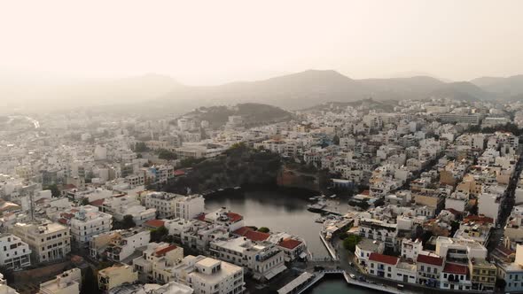 Aerial View of City Agios Nikolaos on a Cloudy Day. Large Lake in the City Center. 